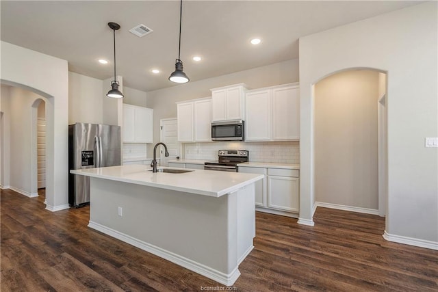 3429 Alsace Ct, Bryan, TX 77808 - kitchen with appliances with stainless steel finishes, arched walkways, dark wood finished floors, decorative backsplash, and recessed lighting
