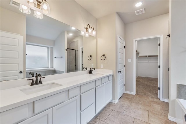 3429 Alsace Ct, Bryan, TX 77808 - bathroom featuring a shower stall, double vanity, a spacious closet, a bathtub, and tile patterned flooring
