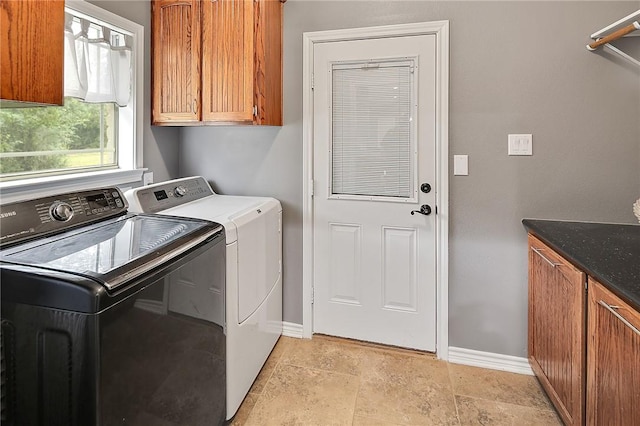 4886 Burt Rd, Bryan, TX 77807 - laundry area featuring cabinet space, washing machine and clothes dryer, baseboards, and light stone finish floors