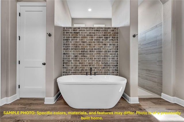 4760 Coral River Rd, College Station, TX 77845 - bathroom featuring baseboards, a freestanding tub, and wood finished floors