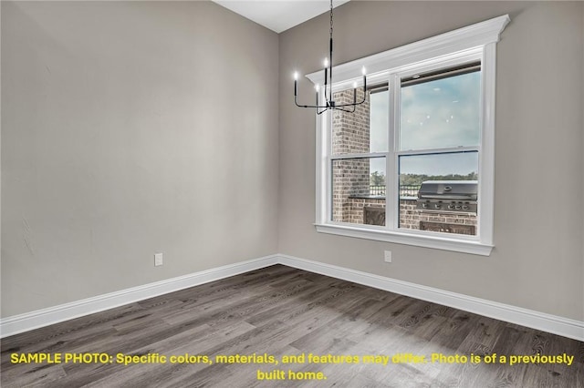 4760 Coral River Rd, College Station, TX 77845 - unfurnished dining area featuring baseboards, dark wood-type flooring, and a notable chandelier
