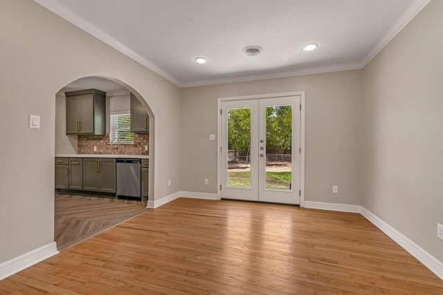 interior space with light wood-type flooring, ornamental molding, french doors, and sink