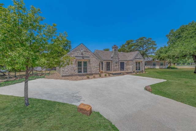 505 Francis Dr, College Station, TX 77840 - view of front of home featuring stone siding, a front yard, driveway, and a chimney