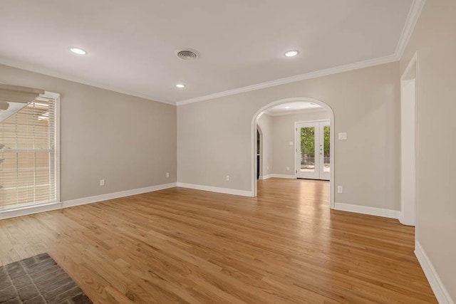 505 Francis Dr, College Station, TX 77840 - spare room featuring arched walkways, light wood-style floors, ornamental molding, recessed lighting, and french doors