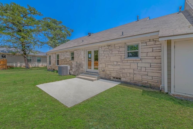 rear view of house with a patio area, cooling unit, a lawn, and french doors