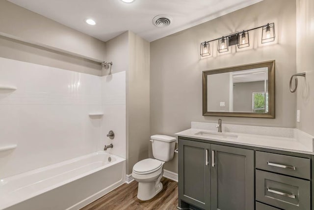 full bathroom featuring hardwood / wood-style flooring, bathtub / shower combination, toilet, and vanity