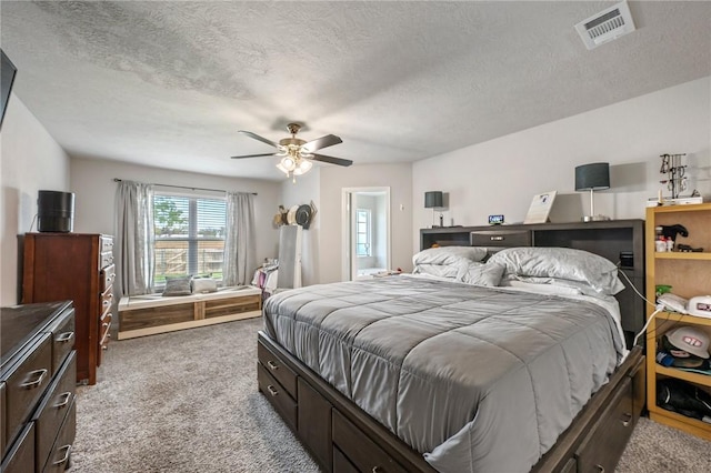 carpeted bedroom featuring a textured ceiling and ceiling fan