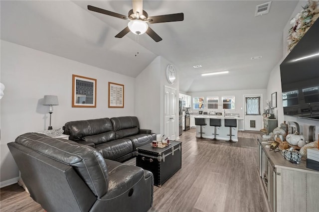 living room with wood-type flooring, ceiling fan, and lofted ceiling