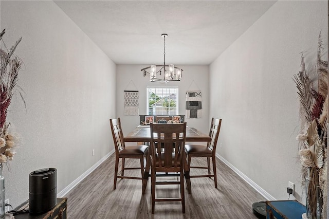 dining space with dark hardwood / wood-style floors and a chandelier