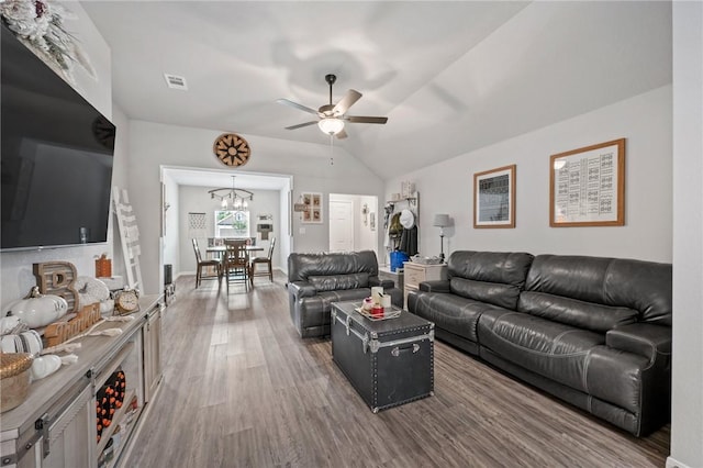 living room featuring hardwood / wood-style floors, ceiling fan with notable chandelier, and lofted ceiling