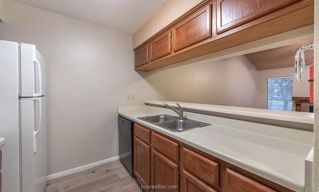 1501 Stallings Dr Unit 69, College Station, TX 77845 - kitchen featuring freestanding refrigerator, dishwasher, light wood-type flooring, light countertops, and brown cabinetry