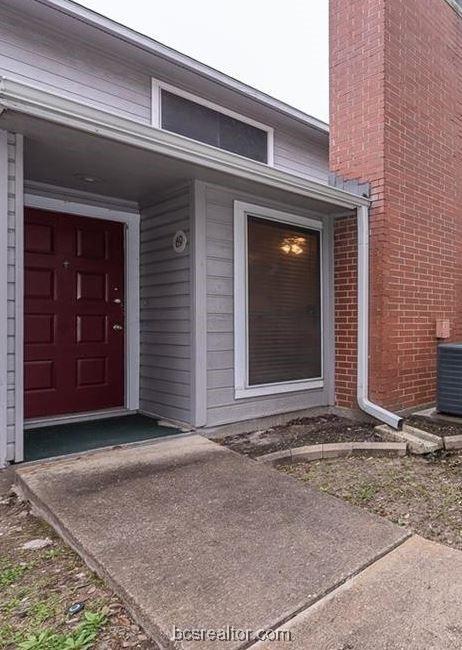 view of exterior entry featuring central air condition unit