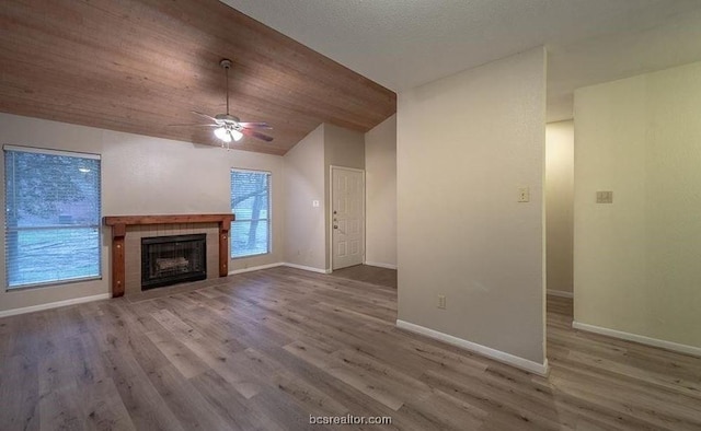 unfurnished living room featuring a tile fireplace, ceiling fan, and hardwood / wood-style floors