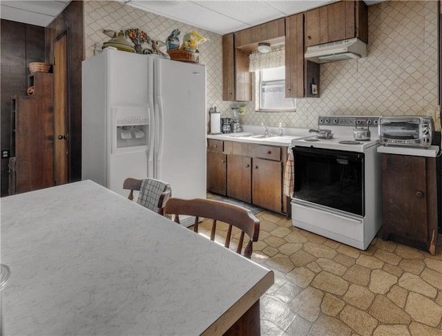 kitchen with decorative backsplash, white appliances, and sink