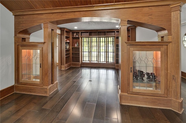 interior space featuring dark hardwood / wood-style floors and wooden walls