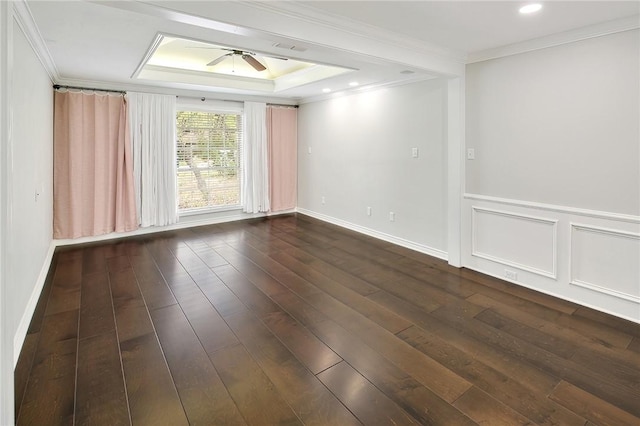 unfurnished room featuring a raised ceiling, crown molding, and dark wood-type flooring