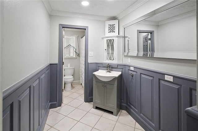 bathroom with tile patterned flooring, vanity, toilet, and ornamental molding