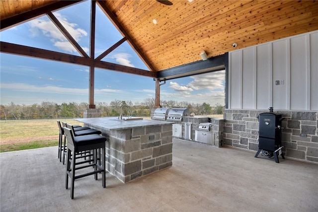 view of patio / terrace featuring a grill, an outdoor kitchen, and an outdoor wet bar