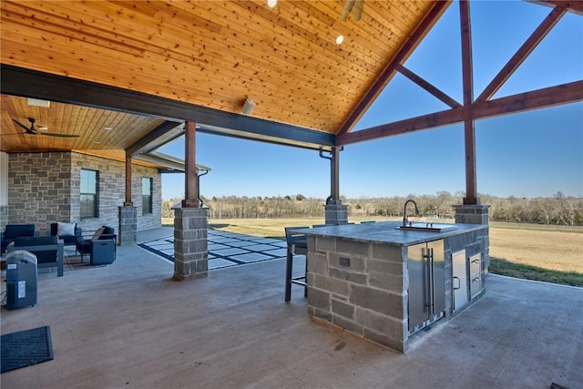 view of patio / terrace with ceiling fan, area for grilling, and an outdoor wet bar