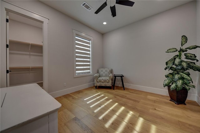 living area with light hardwood / wood-style floors and ceiling fan