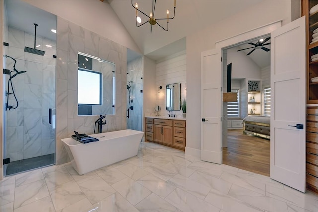 bathroom featuring ceiling fan with notable chandelier, vanity, independent shower and bath, and vaulted ceiling