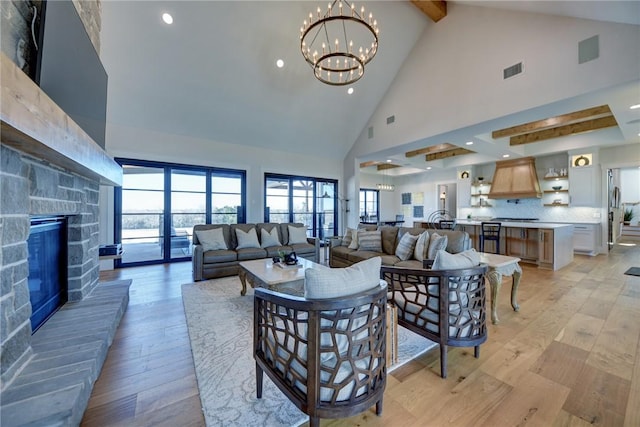 living room featuring an inviting chandelier, high vaulted ceiling, light hardwood / wood-style floors, and beamed ceiling