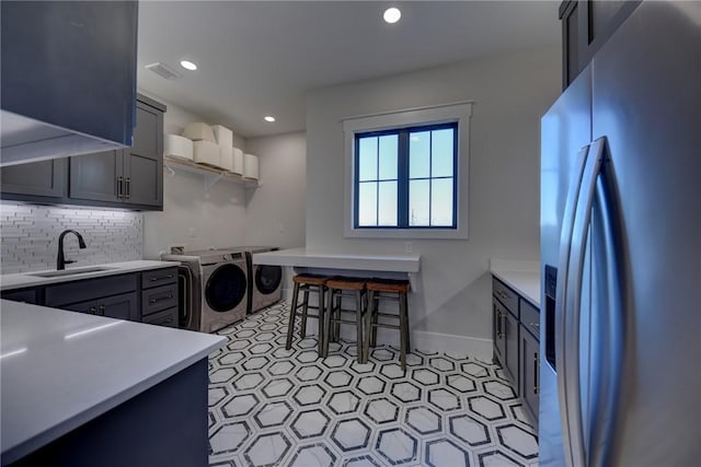 clothes washing area featuring sink, cabinets, and washer and dryer