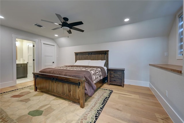 bedroom with vaulted ceiling, ensuite bathroom, ceiling fan, and light hardwood / wood-style flooring