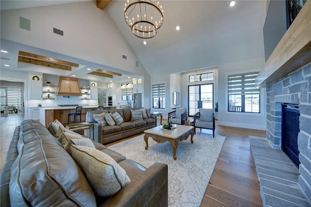 living room with hardwood / wood-style floors, a notable chandelier, high vaulted ceiling, and beamed ceiling