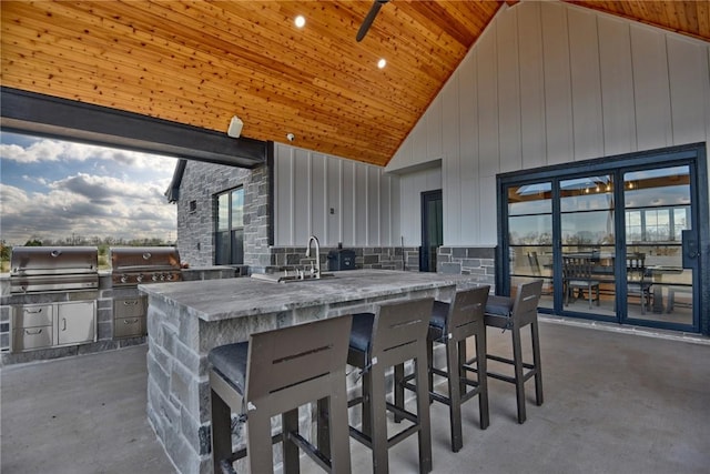 view of patio / terrace featuring grilling area, exterior kitchen, and a wet bar