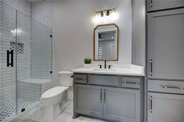 bathroom featuring vanity, a shower with shower door, and toilet