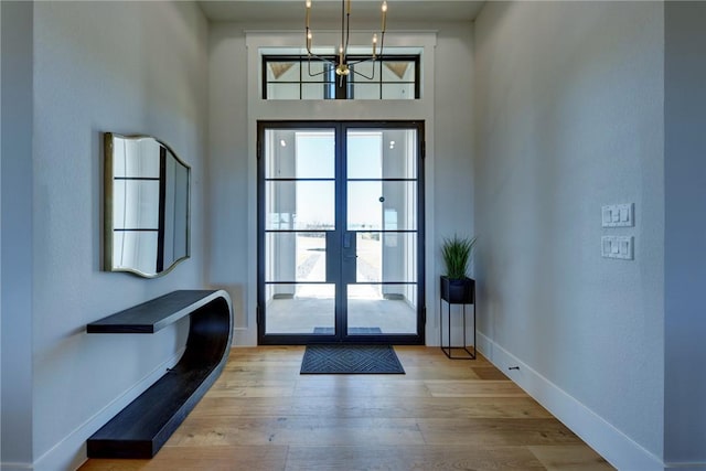 foyer with french doors, plenty of natural light, and light wood-type flooring