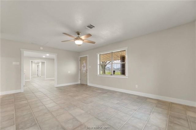 tiled spare room featuring ceiling fan