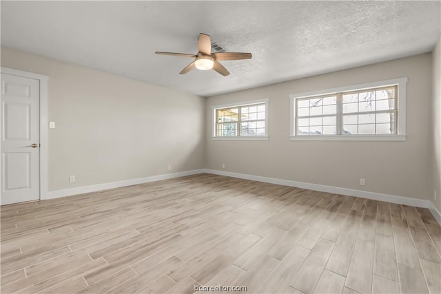 empty room featuring ceiling fan, a textured ceiling, and light wood-type flooring