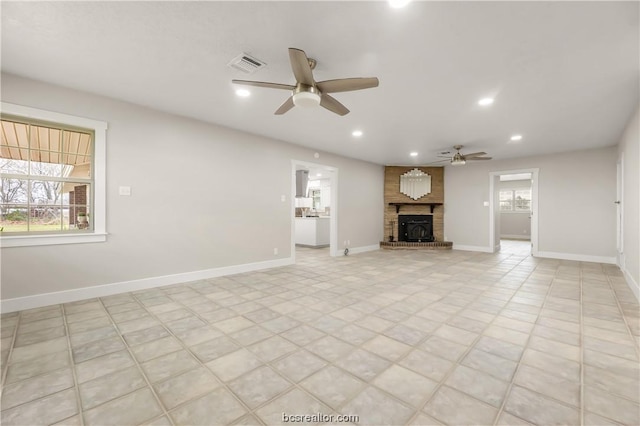 unfurnished living room with ceiling fan, light tile patterned flooring, and a fireplace