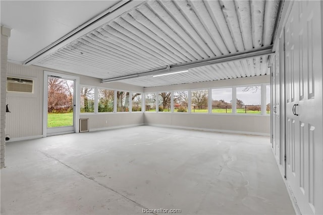 unfurnished sunroom with a healthy amount of sunlight and a wall unit AC