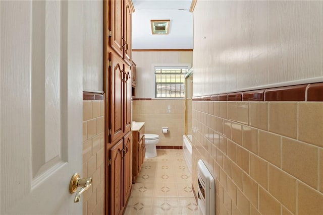 1704 N Pacific St, Conroe, TX 77301 - full bath with toilet, a wainscoted wall, tile walls, and heating unit