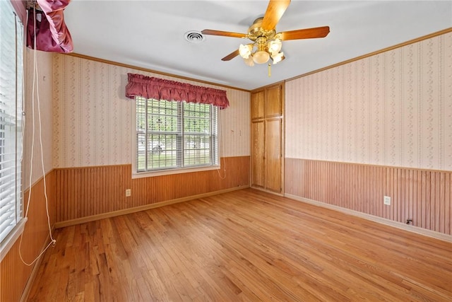 1704 N Pacific St, Conroe, TX 77301 - spare room featuring hardwood / wood-style flooring, ceiling fan, ornamental molding, and a wainscoted wall