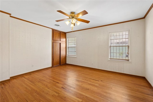 1704 N Pacific St, Conroe, TX 77301 - spare room with light wood-style flooring, a ceiling fan, crown molding, and baseboards