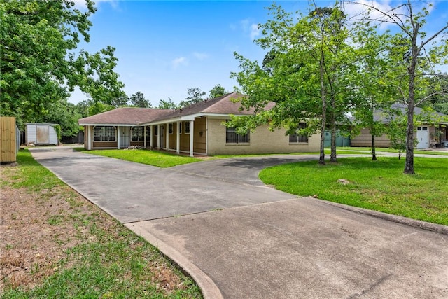 1704 N Pacific St, Conroe, TX 77301 - single story home featuring curved driveway, a front lawn, and brick siding