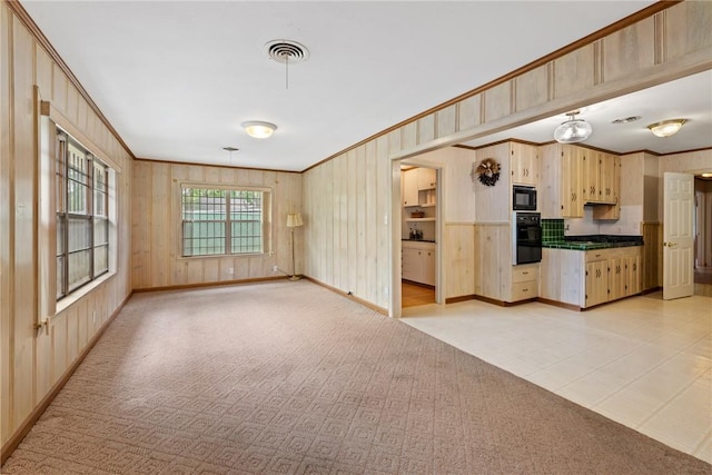 1704 N Pacific St, Conroe, TX 77301 - kitchen featuring light brown cabinetry, black appliances, crown molding, baseboards, and wooden walls