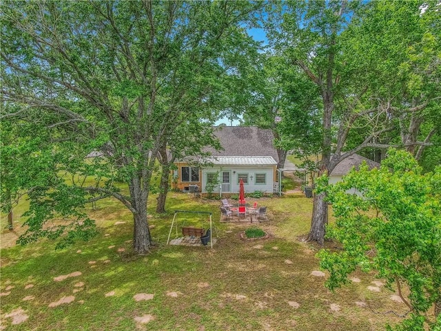 view of green lawn with a patio area