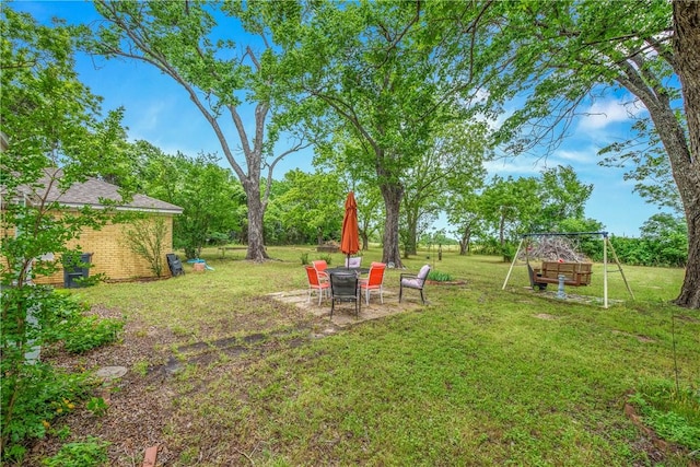 view of green lawn featuring a patio and a playground