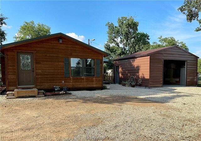 back of property featuring a garage and an outdoor structure