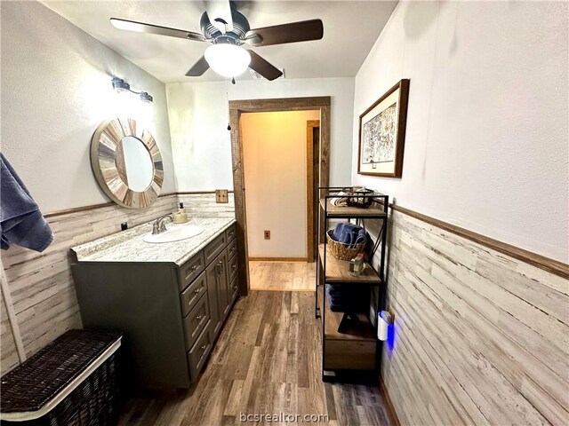 bathroom featuring hardwood / wood-style floors, vanity, ceiling fan, and tile walls