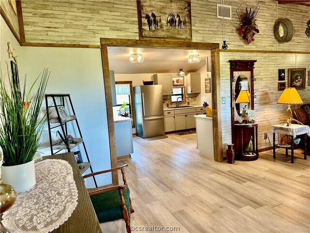 interior space featuring light wood-type flooring, sink, and high vaulted ceiling