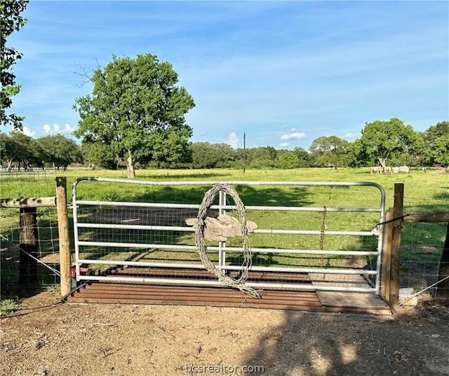 view of gate with a rural view