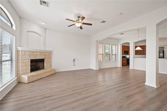 4118 Cedar Creek Ct, College Station, TX 77845 - unfurnished living room with a ceiling fan, a stone fireplace, wood finished floors, and baseboards