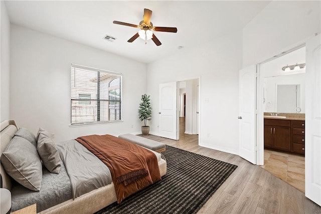 4118 Cedar Creek Ct, College Station, TX 77845 - bedroom with a sink, light wood-type flooring, ensuite bath, ceiling fan, and baseboards