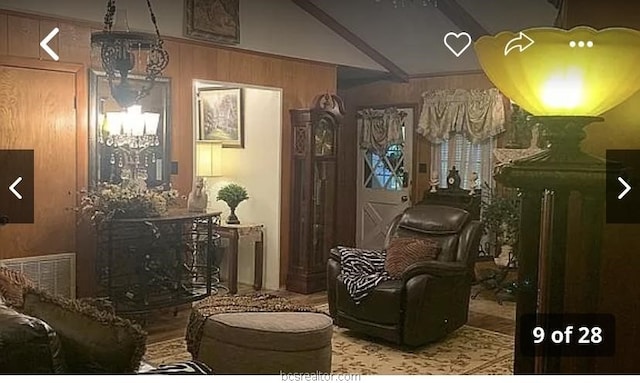 sitting room featuring wooden walls and a chandelier